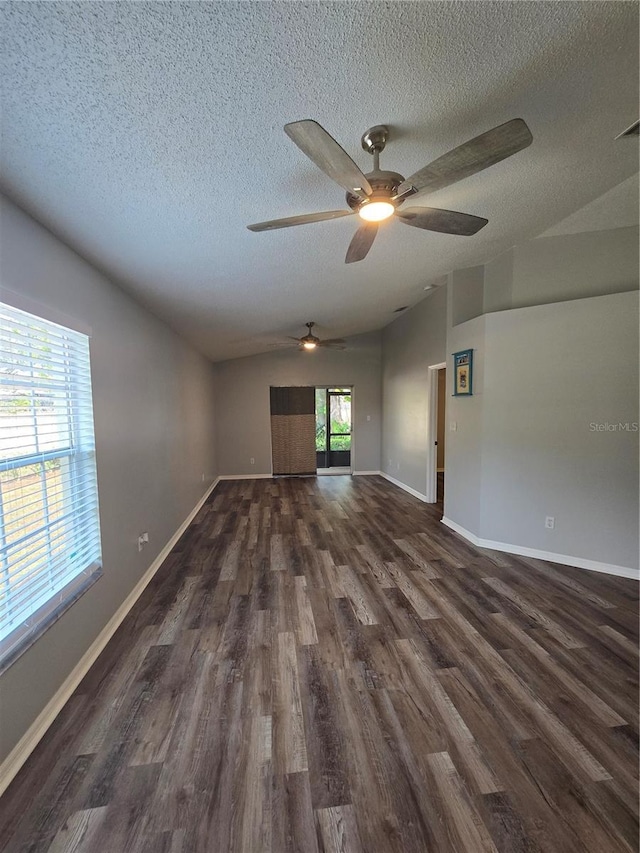 spare room with dark wood-type flooring, vaulted ceiling, and a textured ceiling