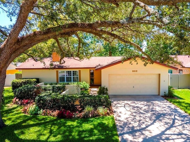 single story home with a garage and a front lawn