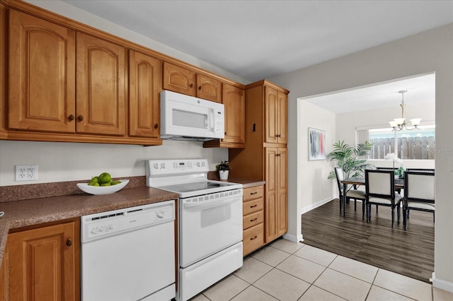 kitchen with white appliances, a notable chandelier, and light tile patterned floors