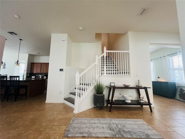 stairs with tile patterned flooring and sink