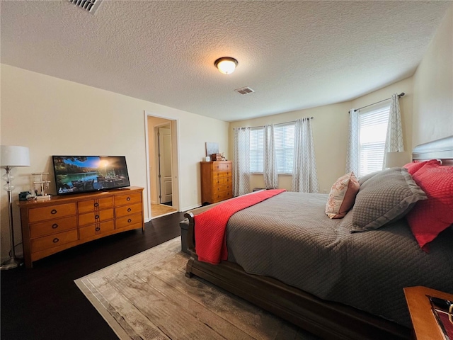 bedroom with dark wood-type flooring and a textured ceiling