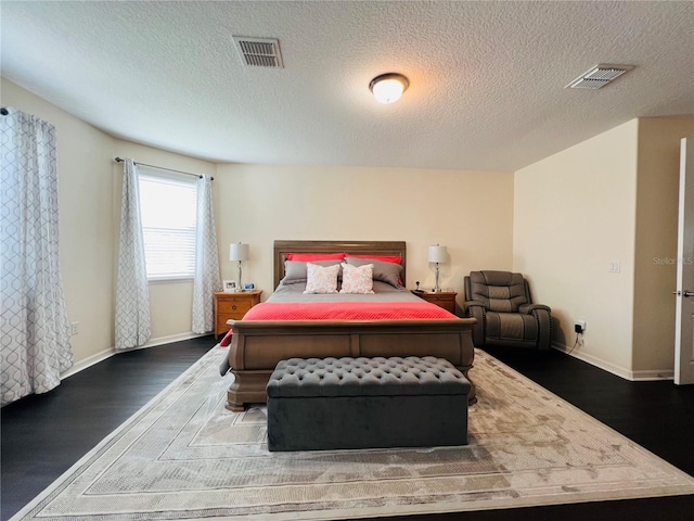 bedroom featuring dark hardwood / wood-style floors and a textured ceiling