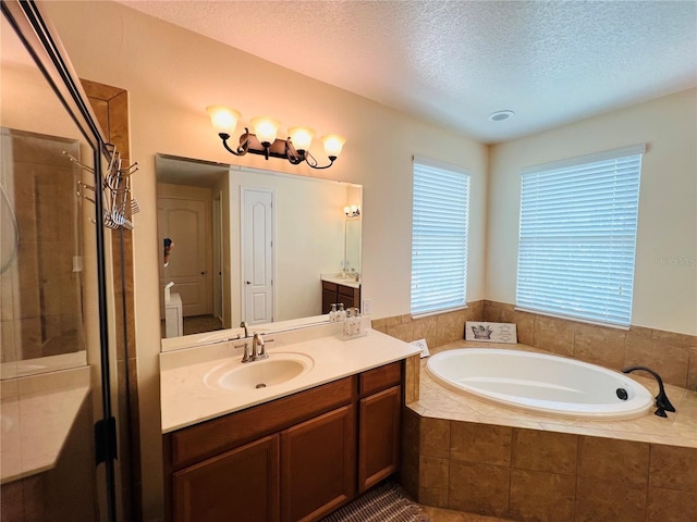 bathroom featuring vanity, plus walk in shower, and a textured ceiling