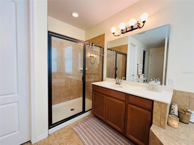 bathroom featuring vanity, tile patterned flooring, a textured ceiling, and walk in shower