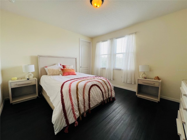 bedroom with dark hardwood / wood-style floors