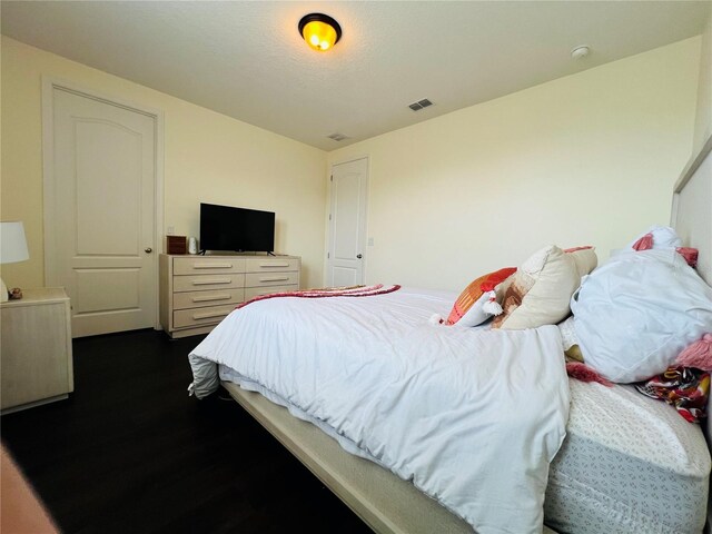 bedroom with dark hardwood / wood-style floors and a textured ceiling