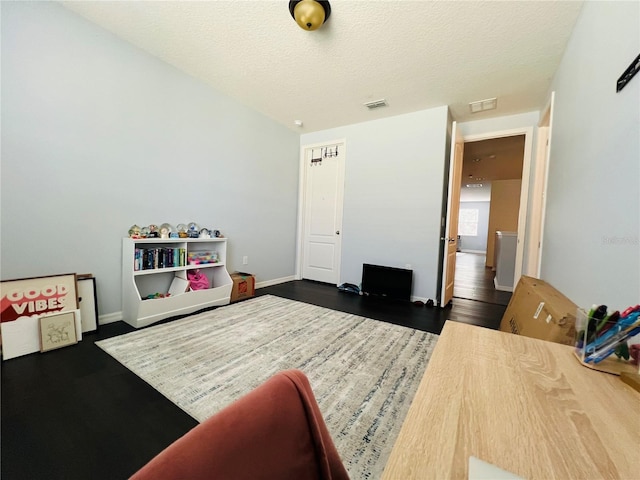 recreation room featuring dark hardwood / wood-style flooring and a textured ceiling