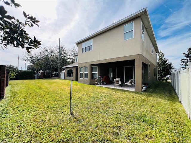 rear view of property featuring a patio and a yard