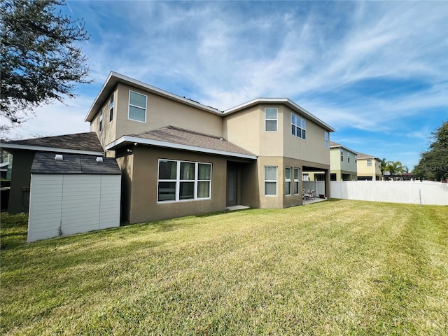 rear view of property with a shed and a yard