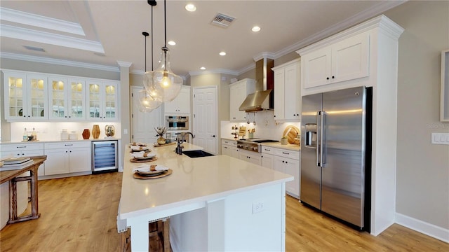 kitchen with wall chimney range hood, sink, appliances with stainless steel finishes, white cabinets, and beverage cooler