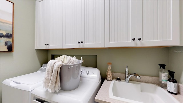 laundry area with cabinets, washer and clothes dryer, and sink