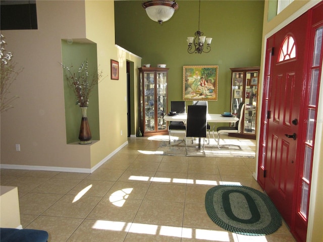 foyer entrance with light tile patterned flooring, a towering ceiling, and a notable chandelier