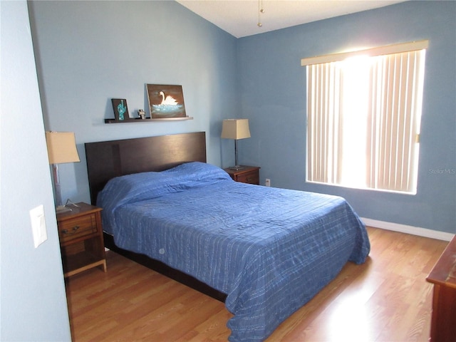 bedroom with wood-type flooring and lofted ceiling