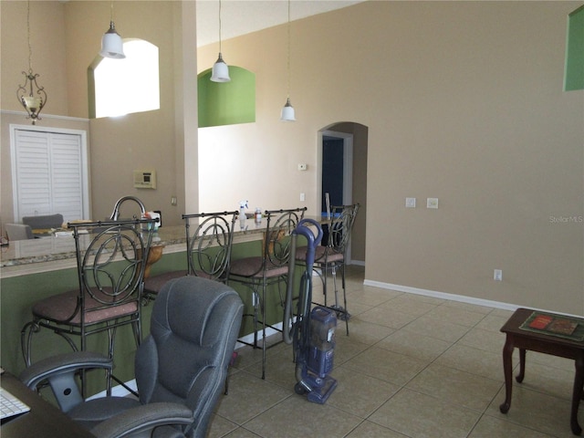 dining space featuring tile patterned flooring and a high ceiling