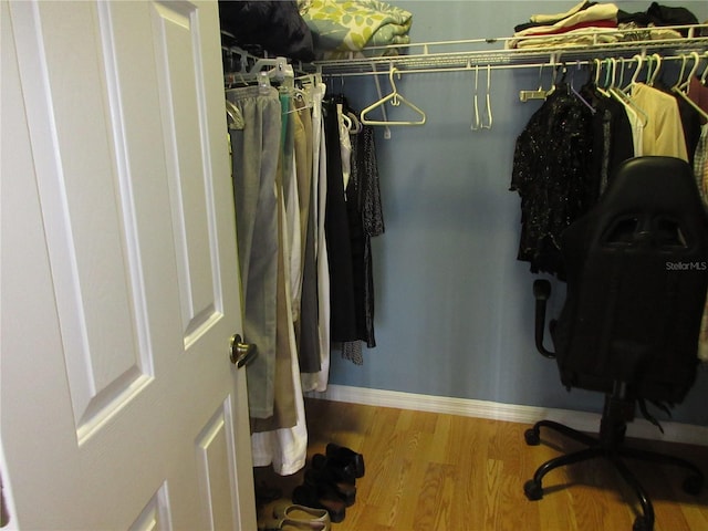 walk in closet with hardwood / wood-style floors