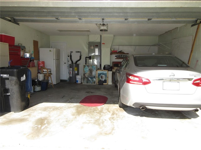 garage with a garage door opener, white fridge, and electric water heater