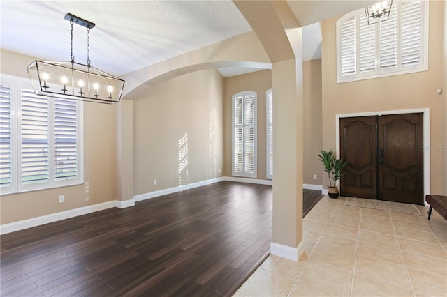 foyer entrance with light wood-type flooring and a notable chandelier