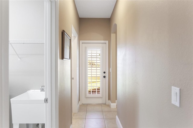 corridor with light tile patterned flooring and sink