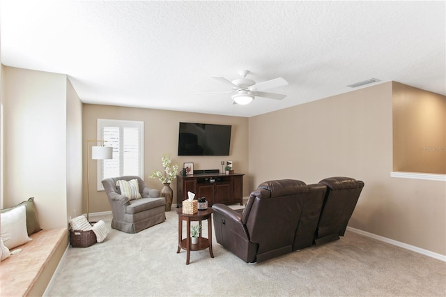 living room featuring a textured ceiling, light carpet, and ceiling fan