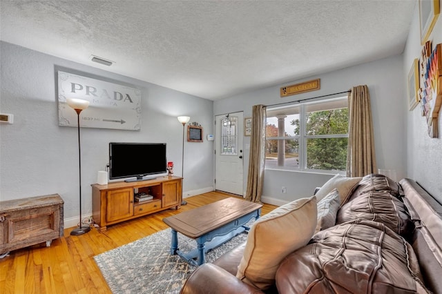 living room featuring light hardwood / wood-style flooring and a textured ceiling