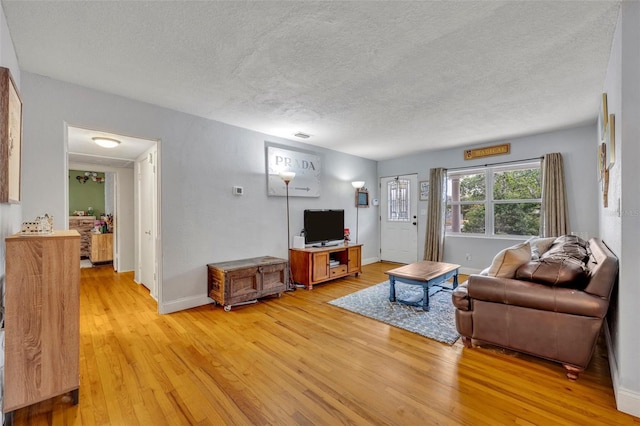 living room featuring light hardwood / wood-style flooring and a textured ceiling