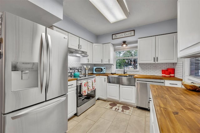 kitchen with butcher block countertops, stainless steel appliances, and white cabinets