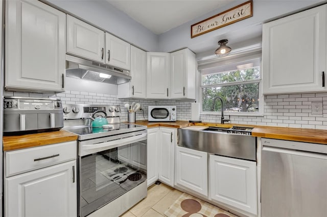 kitchen with stainless steel appliances, butcher block countertops, and white cabinets