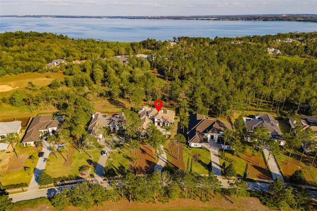 aerial view with a forest view, a water view, and a residential view