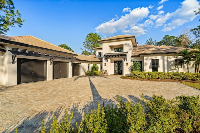 view of front of home with a garage, decorative driveway, and stucco siding