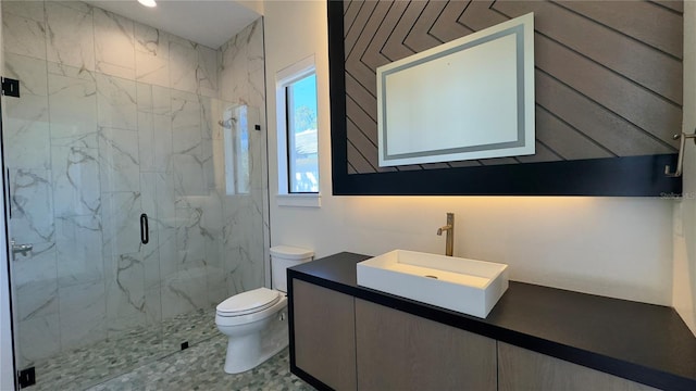 full bathroom with vanity, a marble finish shower, and toilet