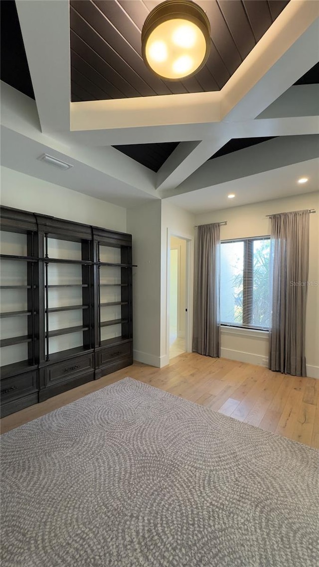 interior space featuring recessed lighting, a raised ceiling, baseboards, and wood finished floors