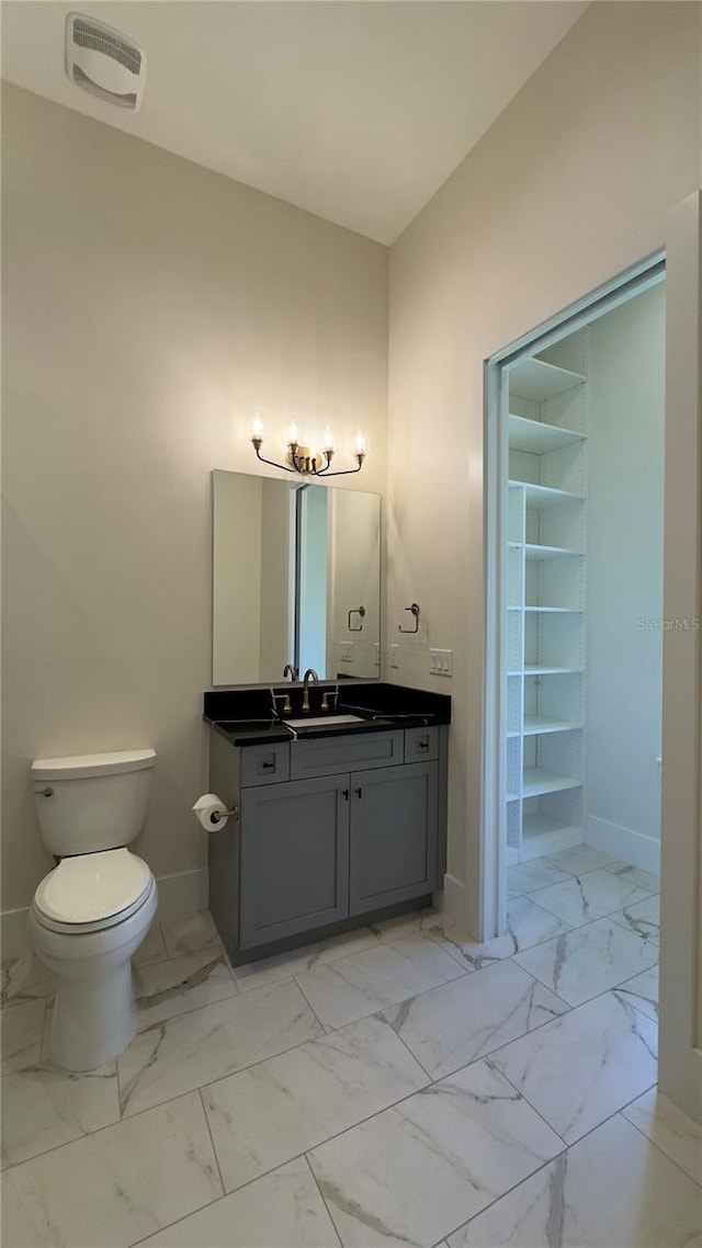 bathroom featuring visible vents, baseboards, toilet, marble finish floor, and vanity