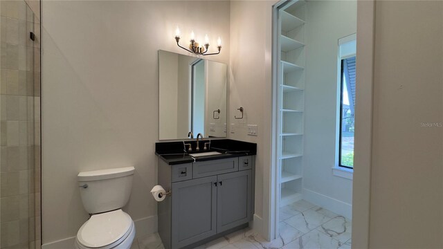 bathroom with marble finish floor, toilet, vanity, and baseboards