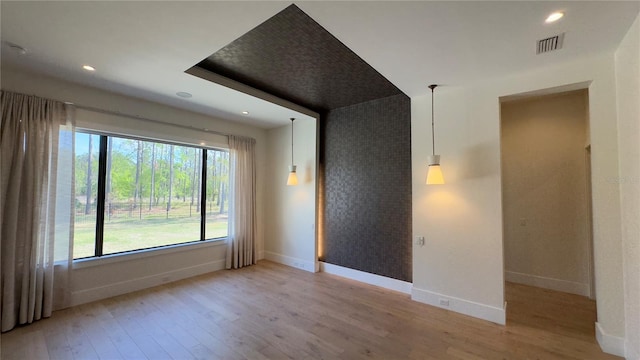 empty room with recessed lighting, wood finished floors, visible vents, and baseboards