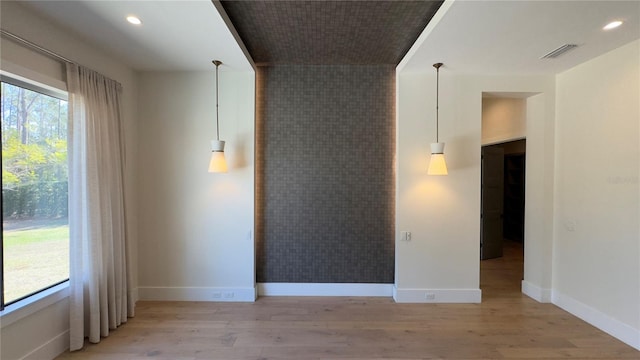 spare room featuring light wood-type flooring, visible vents, baseboards, and recessed lighting