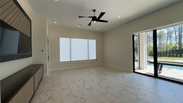 spare room featuring a ceiling fan, recessed lighting, marble finish floor, and baseboards