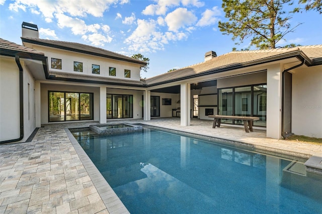 view of swimming pool with a pool with connected hot tub and a patio