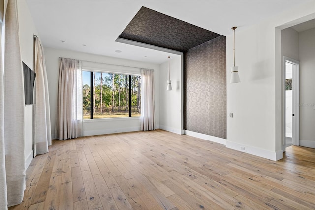 unfurnished living room featuring hardwood / wood-style flooring and baseboards