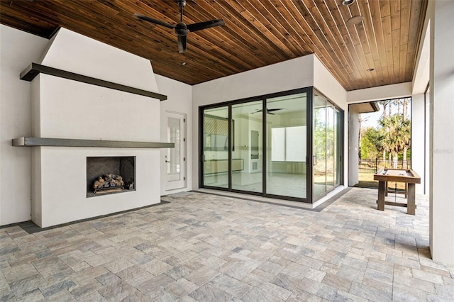 view of patio featuring ceiling fan and an outdoor fireplace