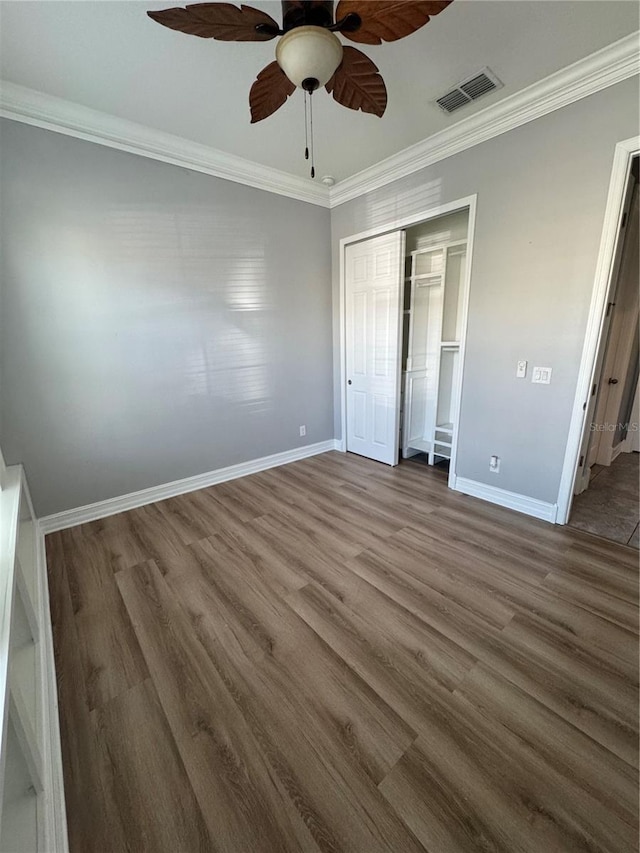 unfurnished bedroom featuring hardwood / wood-style floors, ornamental molding, a closet, and ceiling fan