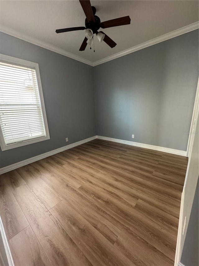 empty room with hardwood / wood-style flooring, ornamental molding, and ceiling fan