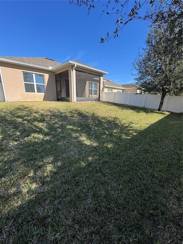 rear view of property with a lawn and a sunroom