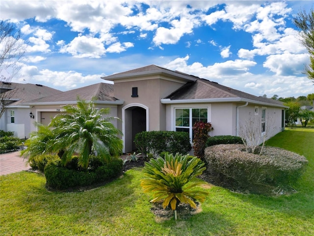 single story home with a garage and a front lawn