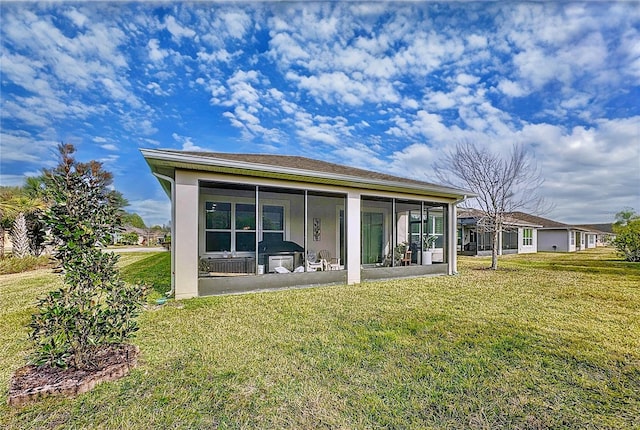 rear view of property featuring a yard and a sunroom