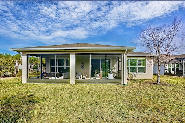 rear view of property featuring a patio, a sunroom, and a yard