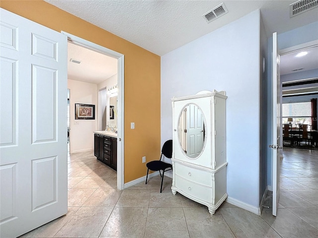 bathroom featuring tile patterned flooring, vanity, and a textured ceiling