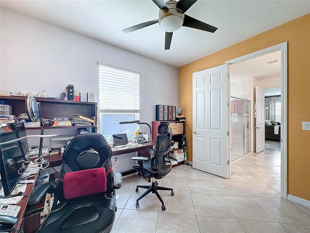 tiled office featuring ceiling fan and a textured ceiling