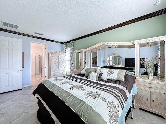 tiled bedroom featuring decorative columns, ornamental molding, connected bathroom, and a textured ceiling