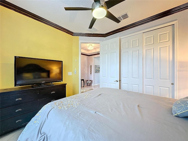 bedroom with ornamental molding, ceiling fan, and a closet