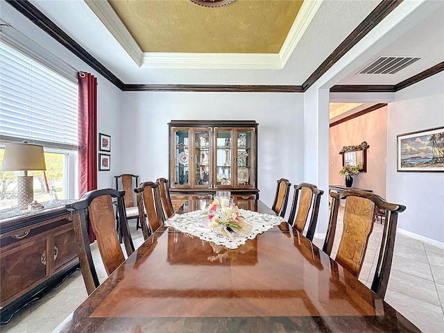 dining space with a raised ceiling, crown molding, light tile patterned floors, and a textured ceiling